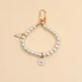 Close-up detail of vintage style pearl keychain with gold flower and lollipop charms - Lollipop Pearl Chain (037-3)
