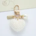 Elegant close-up of a white pearl heart keychain with gold alloy clasp and charms - Artificial Pearl Heart