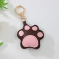 Detail view of a cute brown and pink leather cat paw keychain with golden hardware - Brown