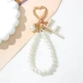 Detailed macro view of pearl letter keychain with golden heart clasp and charms - Letter F Style / Pearl White