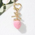 Close-up of a sweet pink strawberry keychain with a rhinestone bow and heart clasp - Solid Light Pink