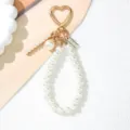 Macro detail view of elegant pearl keychain featuring heart buckle and gold accents - Letter I Style / Pearl White