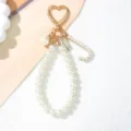 Close-up detail of elegant pearl keychain featuring golden heart clasp and pearl letter C charm - Letter J Style / Pearl White
