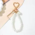 Close-up of elegant pearl letter L keychain with gold heart-shaped clasp and pearl charm - Letter L Style / Pearl White