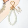 Detailed view of white pearl keychain with gold heart clasp and letter M charm - Letter M Style / Pearl White