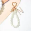 Close-up of elegant pearl keychain with gold heart clasp and pearl 'M' charm - Letter N Style / Pearl White