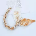 Detailed view of fashionable silk scarf phone strap with golden clasp and floral print - Style V
