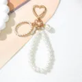 Close-up detail of a pearl keychain featuring a gold heart-shaped clip and elegant beaded charms - Letter O Style / Pearl White