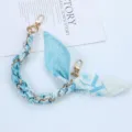 Detailed macro shot of light blue floral silk scarf phone lanyard chain with gold clasps - Style K