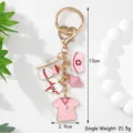 Detailed macro view of a medical themed pink keychain featuring nurse hat and syringe charms - Pink