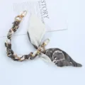 Detailed view of a short phone strap featuring a gold chain and patterned silk scarf - Style D