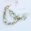 Close-up of golden chain phone strap interwoven with green floral silk scarf - Style C
