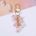Detailed view of sweet pink cherry blossom and white pearl keychain with gold metal clasp - Pink