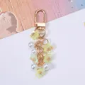 Detailed view of a sweet cherry blossom keychain with pearls and golden clasp - Yellow