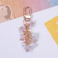 Close-up detail of a sweet purple cherry blossom and faux pearl keychain charm for bags - Purple