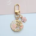 Detailed macro view of an elegant gold-toned cherry blossom keychain with pearls. - U-Clasp Style (A026) / Pink