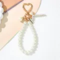 Close-up of elegant pearl keychain with gold heart-shaped clip and cross charm - Letter T Style / Pearl White