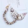 Detail view of gold chain phone strap interwoven with decorative printed silk scarf - Style Q