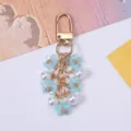 Macro view of floral keychain featuring blue cherry blossoms and elegant white pearls - Sky Blue