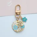 Close-up of gold cherry blossom wreath keychain with blue enamel and pearls. - U-Clasp Style (A026) / Blue