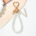 Detailed view of white pearl keychain with heart clasp and letter V charm - Letter V Style / Pearl White