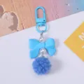 Detail of blue resin bow and soft pom-pom keychain pendant with elegant faux pearl beads - Blue