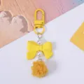 Adorable yellow resin bow keychain with elegant pearls and fluffy pompom detail - Yellow