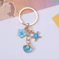 Detailed view of ocean-themed keychain with blue starfish and pearl shell charms - Lake Blue