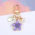 Portachiavi fiore di ciliegio in smalto viola con targhetta dorata e ciondolo perla - Viola