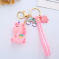 Close-up detail of a cute pink unicorn keychain featuring rainbow and shell charms and a pink strap - Wing Integrated Style / Pink
