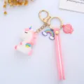 Detailed view of a cute cartoon unicorn keychain with rainbow and pink shell charms - Wing Integrated Style / White