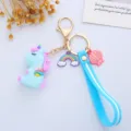 Close-up of a cute blue unicorn keychain with rainbow charm and soft blue silicone strap. - Wing Integrated Style / Blue