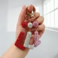 Vue détaillée de porte-clés étincelants en strass lettre L en rouge, argent et rose. - Style L / Rose