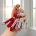 Vue détaillée de porte-clés lettre M en strass étincelants rouge, rose et argenté pour sacs - Style Lettre M / Blanc