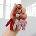 Détail macro de porte-clés alphabet M N W de luxe sertis de strass brillants en main - Motif N / Rose