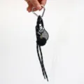 Detailed view of dark aesthetic keychain with heart carabiner, dice, and pom-pom - Black