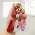 Vue détaillée de porte-clés lettre V incrustés de cristaux en rouge, blanc et rose brillant - Style V / Rose