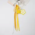 Detailed shot of handmade yellow cherry blossom and leather heart braided keychain - Yellow