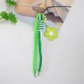 Detailed view of green woven cords and a lime green flower charm on a heart keychain. - Green