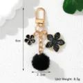 Detail showing the 8cm length and 2.2cm width of the black fur ball flower keychain - Black