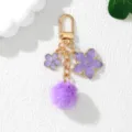 Close-up of a purple cherry blossom keychain with a fluffy pom-pom and gold alloy hook - Purple