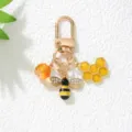 Detailed macro view of a gold-tone bee and honeycomb enamel keychain with rhinestones. - Bee