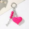 Macro view of bright pink acrylic heart pendant and silver star charm keychain - Rose Red