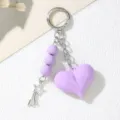 Close-up detail showing the purple acrylic heart keychain with beads and star charm. - Purple