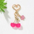 Detailed view of a pink resin cherry keychain with heart clasp and flower charm - Rose Red