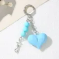 Close-up detail of a light blue acrylic heart keychain with beads and star charm decor - Lake Blue