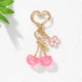 Detail view of pink resin cherry keychain with heart clasp and small blossom pendant - Pink