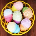 Close-up view of vibrant colorful foam-beaded Easter eggs in a bright yellow basket decor. - Style 3