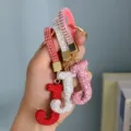 Close-up of three full rhinestone J letter keychains in red, silver and pink. - Pink Rhinestone J