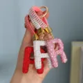 Close-up of sparkling rhinestone-encrusted letter A keychains in red, silver, and pink variants - Pink Rhinestone R